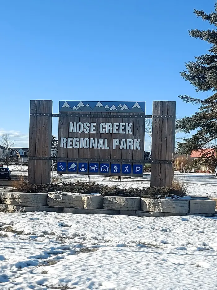 Wooden Nose Creek Regional Park sign in winter snow under a blue sky
