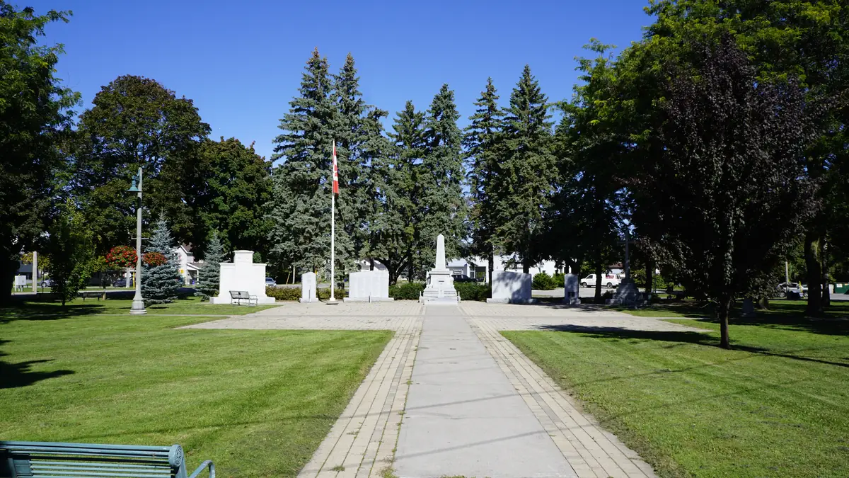 Green mowed lawns, spruce trees and a walkway at Memorial Park in Belleville