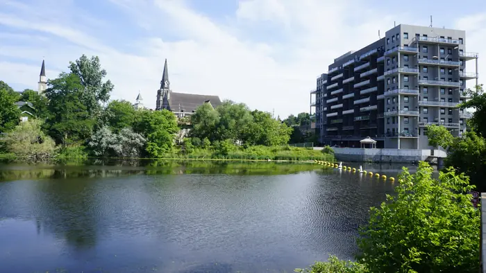 Mill Pond in Hespeler with church spires behind the trees, in a part of town where neighbours ask about the best landscaper in Cambridge