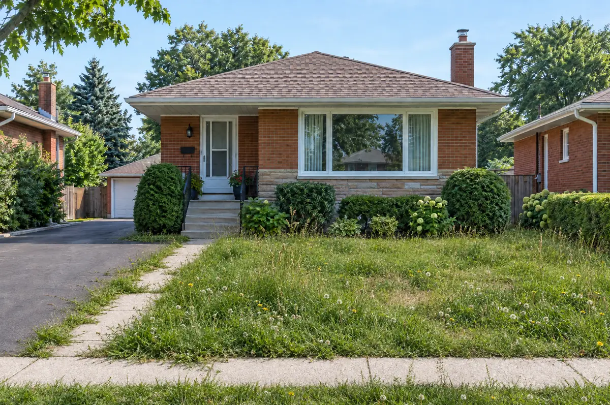 Before: a front lawn left too long, with uneven grass, dandelions and grass spilling over the walkway