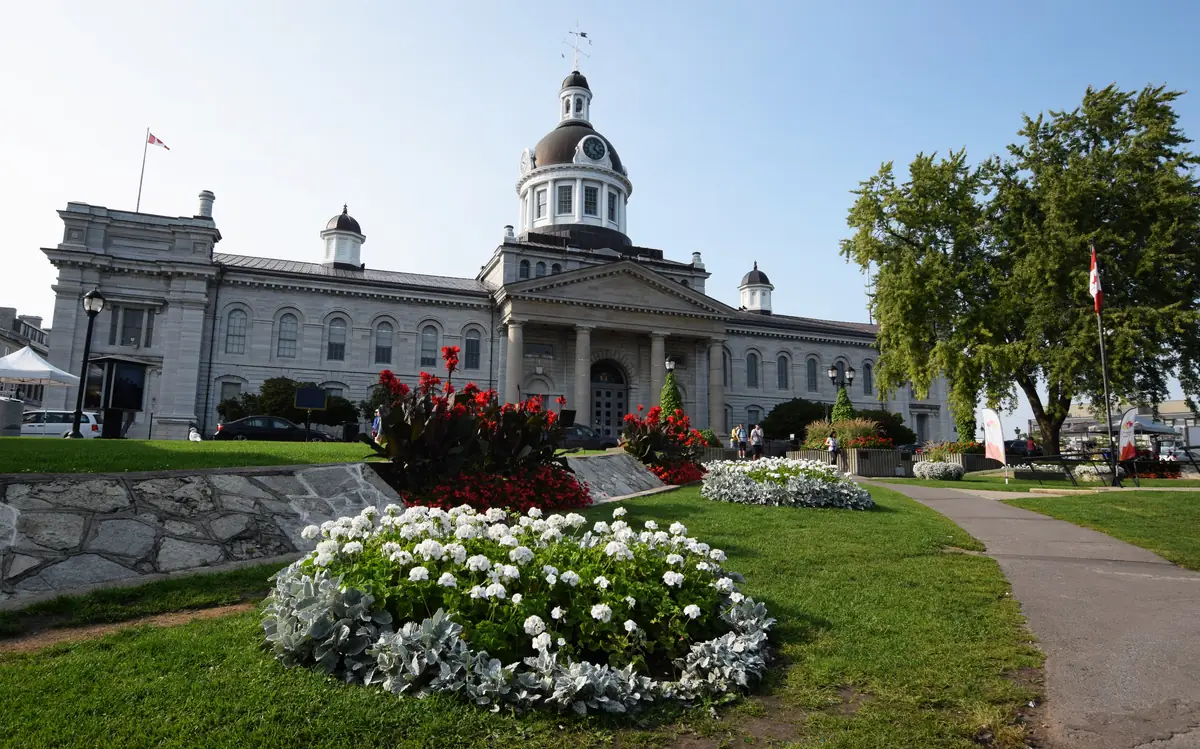 Kingston City Hall behind a trimmed lawn and flower beds