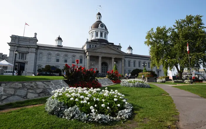 Kingston City Hall behind a trimmed lawn and flower beds, the kind of neat grass the best landscaper in Kingston aims for