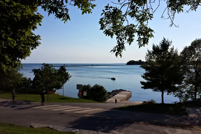 Lawn, shade trees and the boat launch at Lake Ontario Park in Kingston
