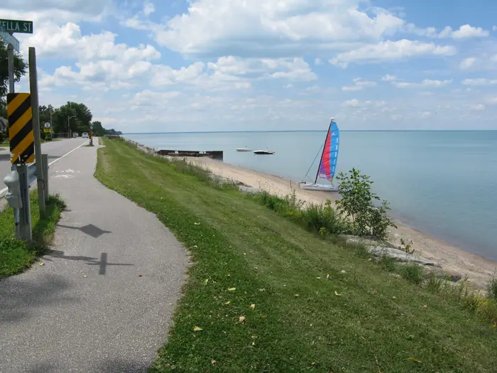 Mowed grass beside a paved path and a sandy Lake Huron beach in Bright's Grove