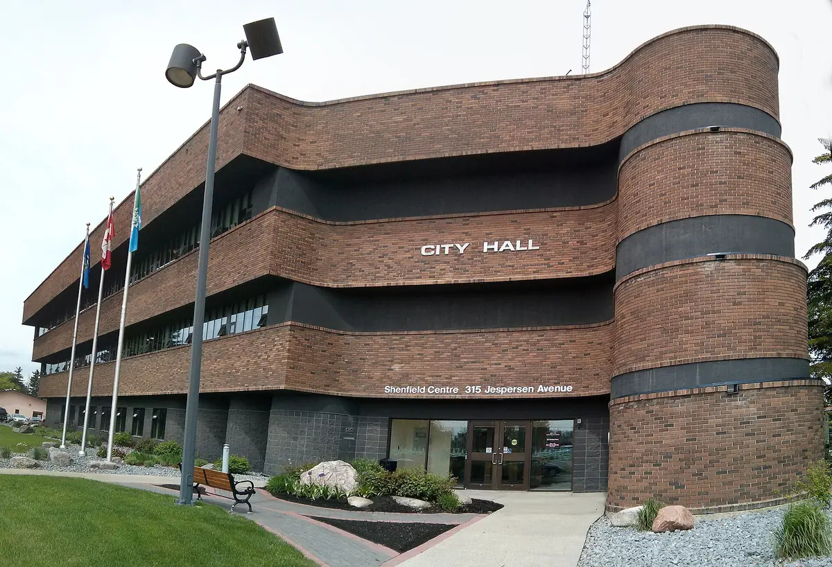 Spruce Grove City Hall with a mowed lawn and garden beds on Jespersen Avenue