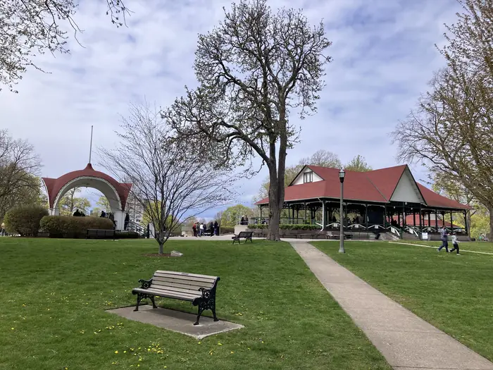 Wide mowed lawn, bench and pavilion in Montebello Park, the kind of green the best landscaper in St. Catharines keeps tidy